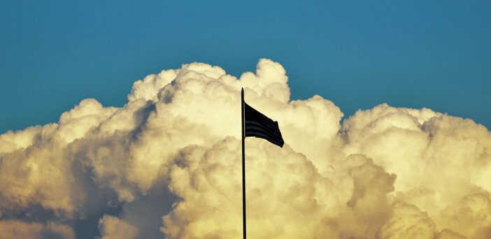 Us Flag in front of clouds