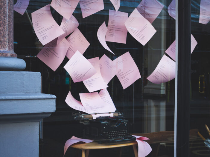 Pink papers flying out of a typewriter