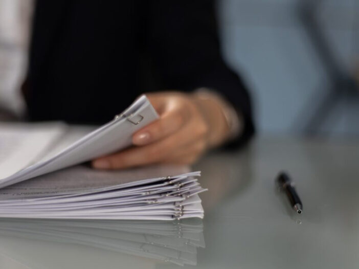 Person working through a pile of paperwork