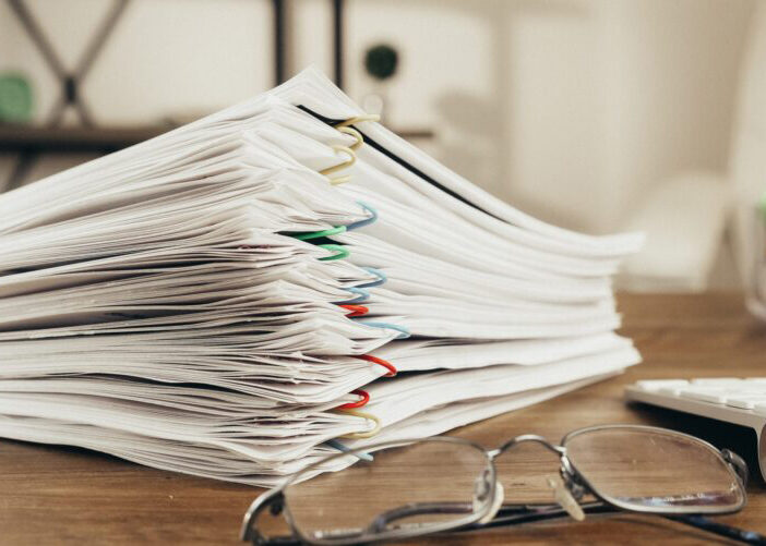 Stack of papers on a desk with paperclips