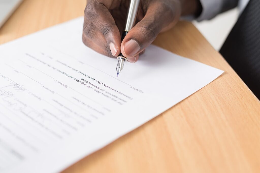 Man signing a paper copy of contract