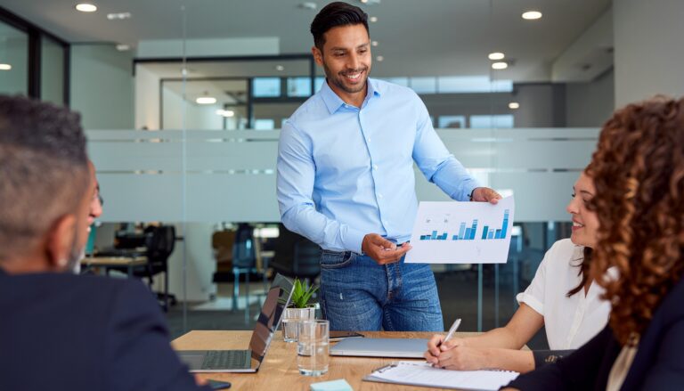 Financial Projections and Scalability​ - a man showing a piece of paper to his team